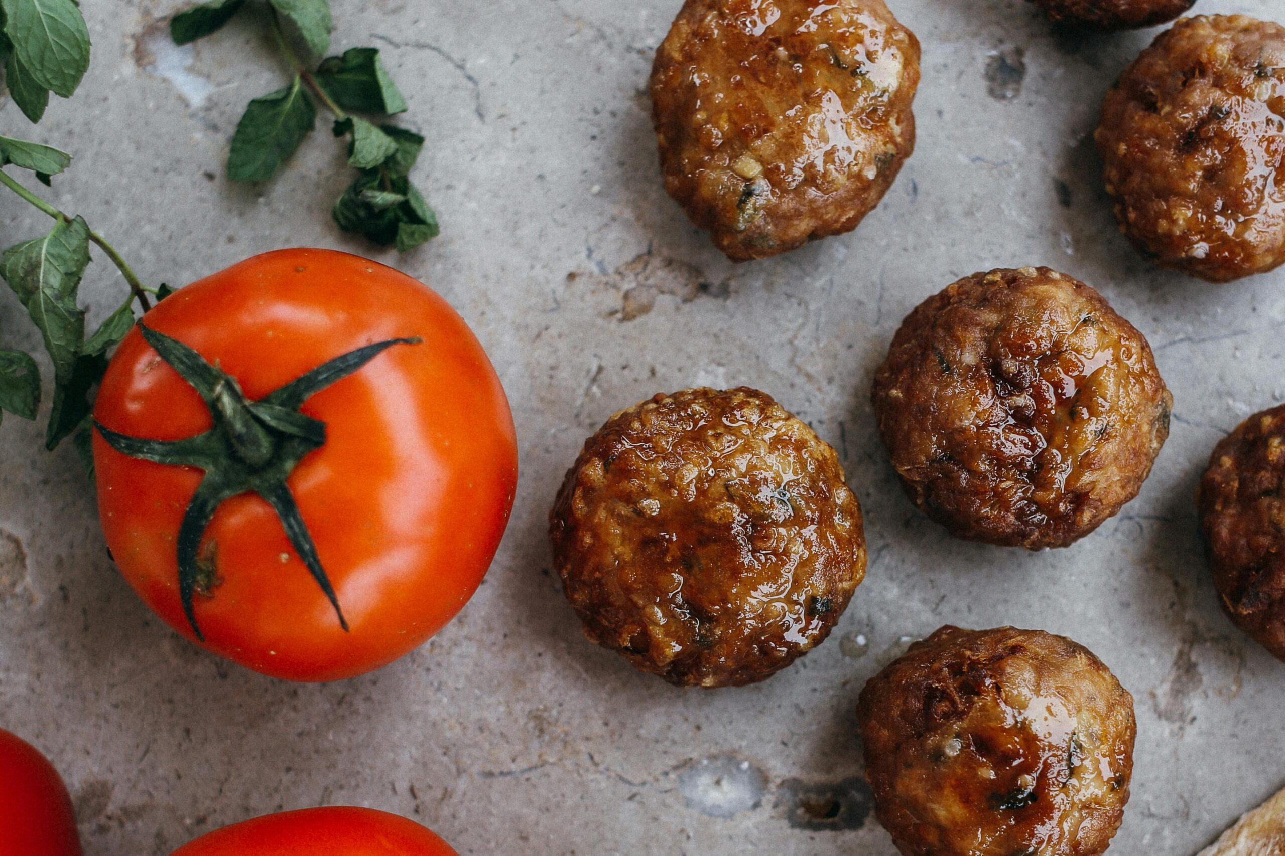 Sheet Pan Meatballs with Tomato Salad and Green Sauce Featured Image
